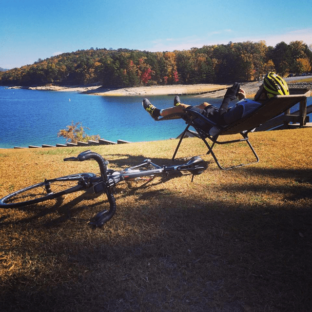 A man laying on the ground next to his bike.