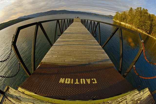 A wooden pier with the word caution written on it.