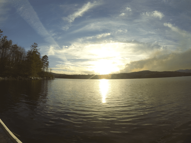 A view of the sun setting over a lake.